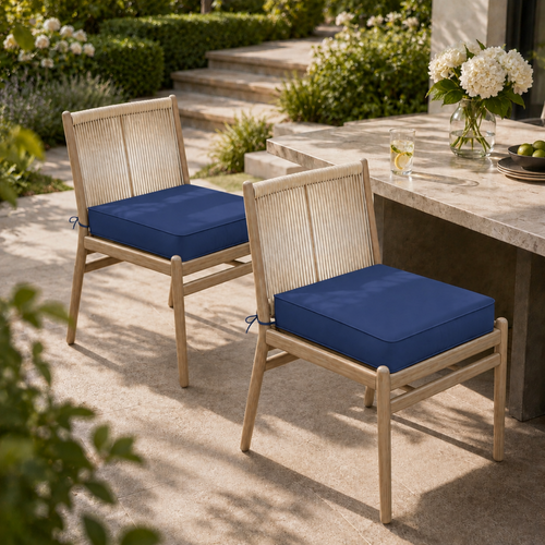 Plush navy blue square outdoor chair cushions on modern light wood chairs with rope-style backrests on a patio.