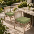 Sage green square outdoor seat cushion with ties on a modern rope-back patio chair.