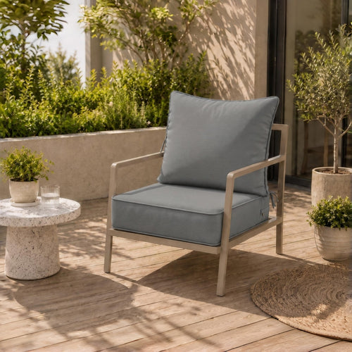 Plush grey water-resistant patio chair cushion with secure ties on a modern metal outdoor chair.